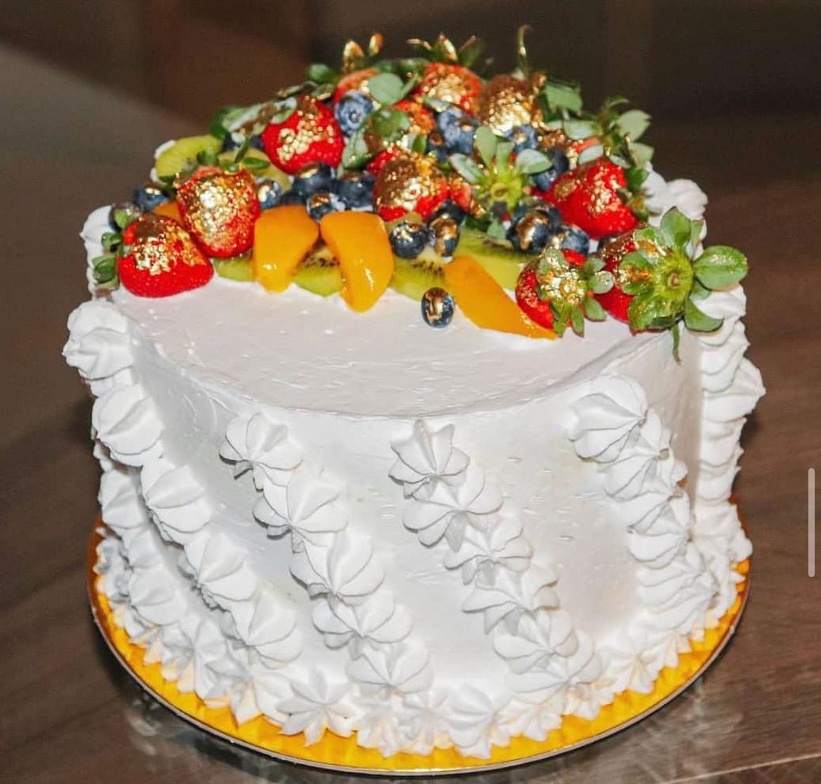 Torta artesanal cocomiel.pty coronada con fresas, kiwi y frutos bañados en pan de oro