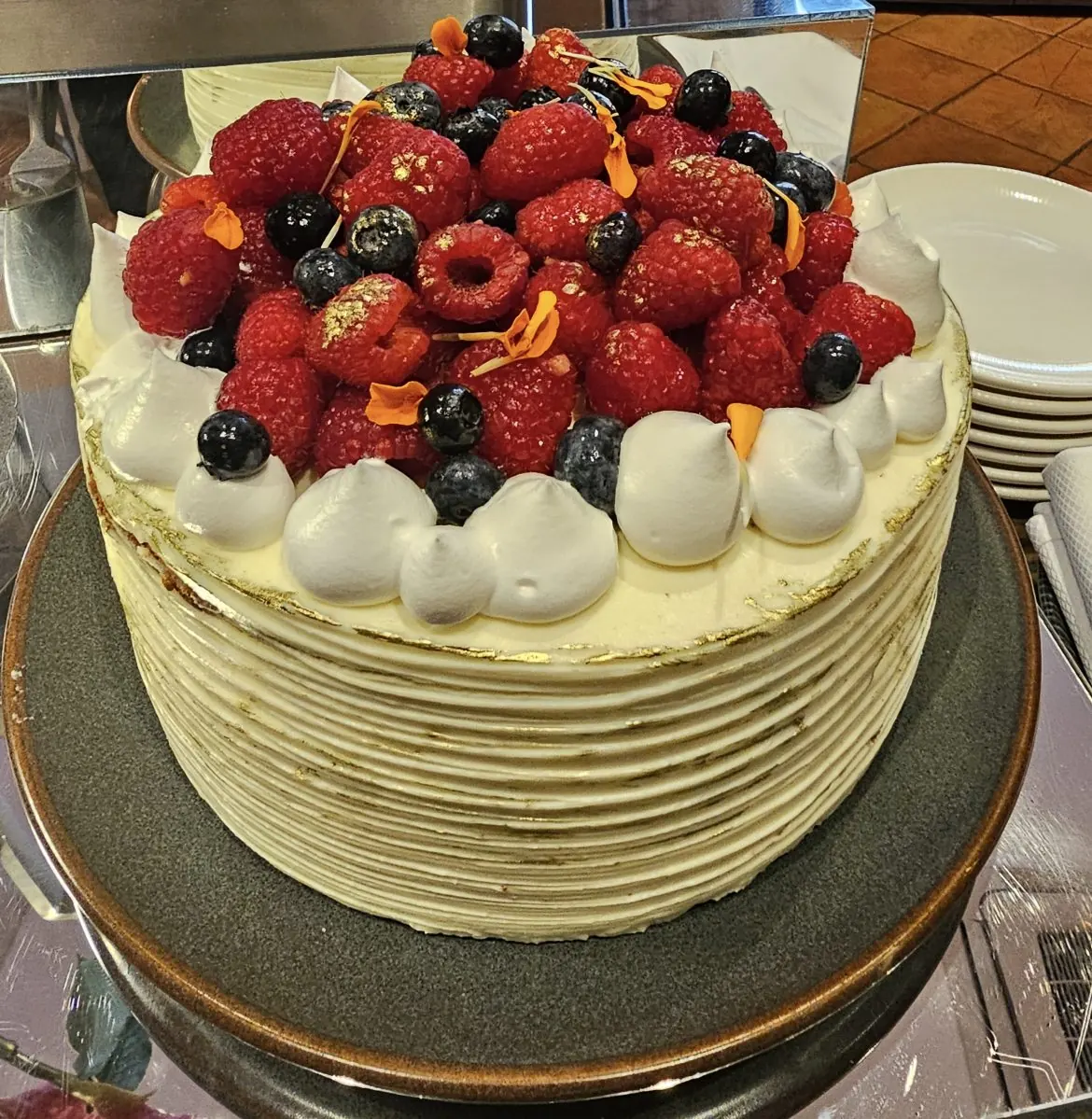 Torta con frambuesas, arándanos y flores comestibles